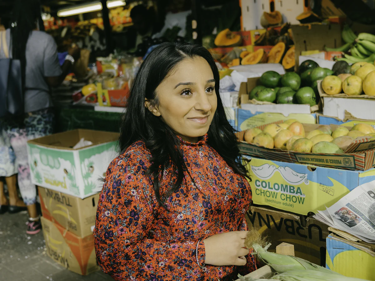 Comerciante sonriendo junto a su puesto de frutas